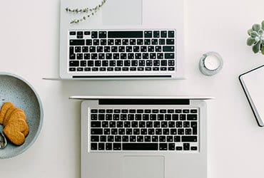 Dos computadoras portátiles sobre una mesa de trabajo